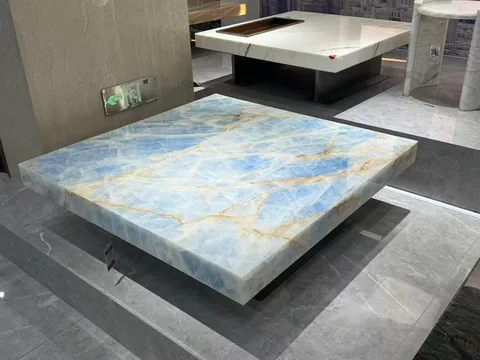 blue stone coffee table, with a rectangular top and bold veining, in a showroom
