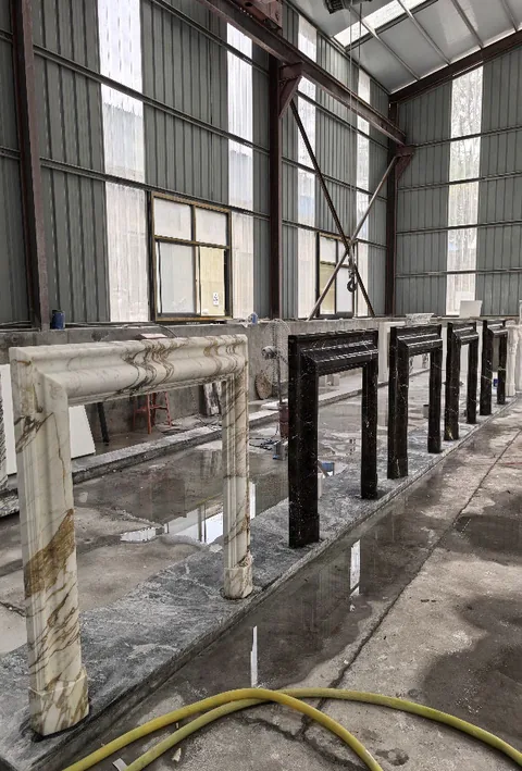 White Volakas marble fireplace surround, with bold veining and a reflective finish, in a workshop