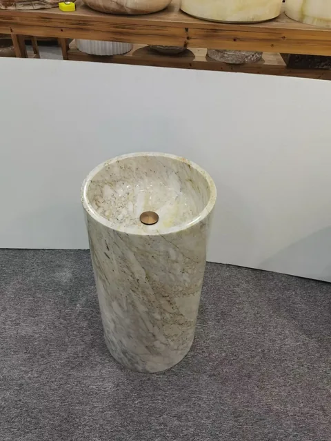 cream-beige stone sink, with fine veining and a reflective finish, in a showroom
