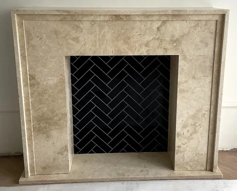White Volakas marble fireplace surround, with cloudy mottling, against a pale background