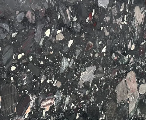 black stone slab, with a single full slab and angular breccia fragments, in a close surface view