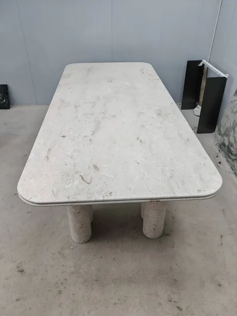white stone dining table, with fine veining, in a workshop