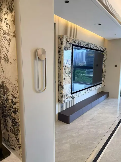 cream-beige stone wall feature, with large veined wall panels and angular breccia fragments, in a furnished room