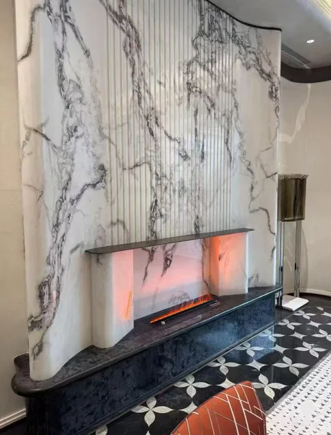 white stone fireplace surround, with bold veining and a reflective finish, in a furnished room