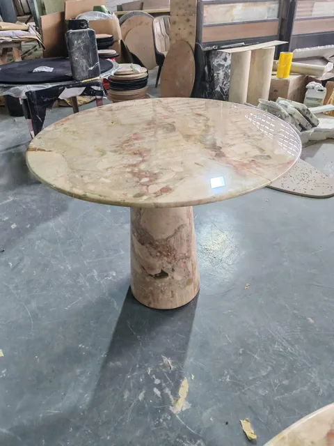 cream-beige stone dining table, with cloudy mottling and a reflective finish, in a workshop
