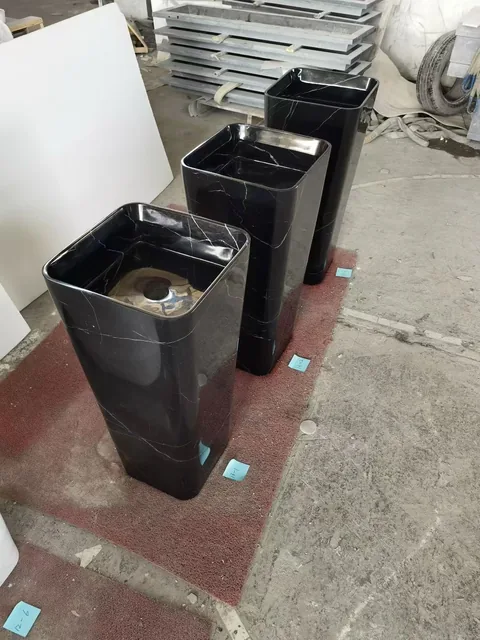 black stone sink, with a form carved from solid stone and fine veining, in a workshop