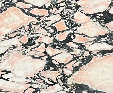 rose-red stone slab, with angular breccia fragments, in a close surface view