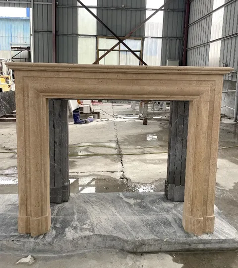 White Volakas marble fireplace surround, with stepped tiers and linear travertine grain, in a workshop