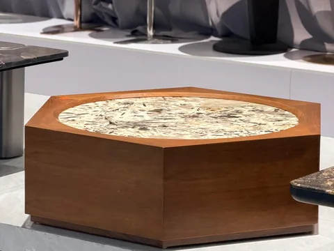 cream-beige stone coffee table, with a solid block base and fine veining, in a showroom