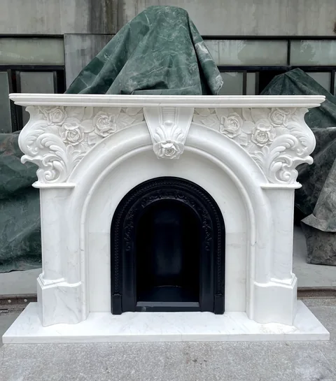 White Volakas marble fireplace surround, with an arched opening and fine veining, in a workshop