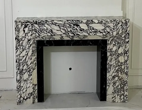 Arabescato Corchia marble fireplace surround, with a straight recessed opening and bold veining, against a pale background