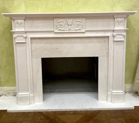 White Volakas marble fireplace surround, with a straight recessed opening and fine veining, against a pale background