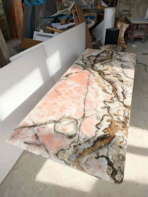 rose-red stone slab, with a single full slab and bold veining, in a workshop