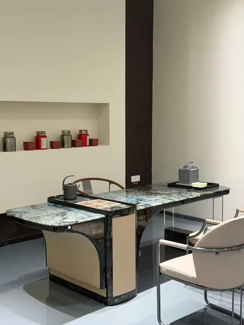 black stone desk, with cloudy mottling and a reflective finish, against a pale background