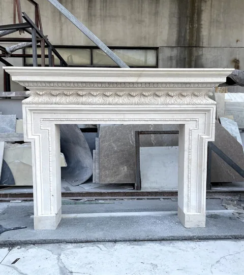 White Volakas marble fireplace surround, with stepped tiers and a plain surface, in a workshop