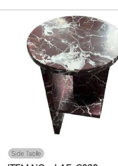 rose-red stone side table, with a round top and bold veining, on a plain backdrop