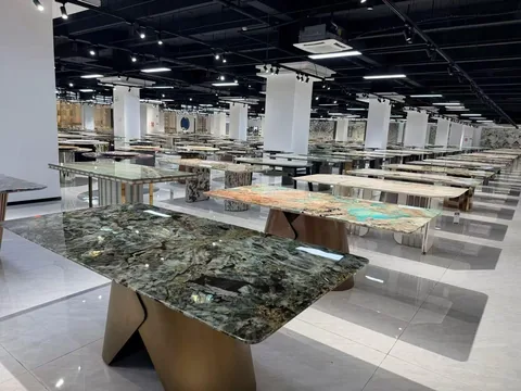 green stone dining table, with bold veining and a reflective finish, in a showroom