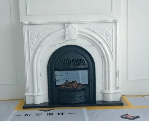 White Volakas marble fireplace surround, with workshop equipment nearby