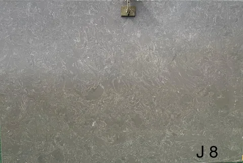 gray engineered stone slab, with cloudy mottling, shown from a frontal view with workshop equipment nearby