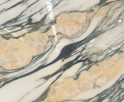 cream-beige stone slab, with bold veining and a reflective finish, in a close surface view