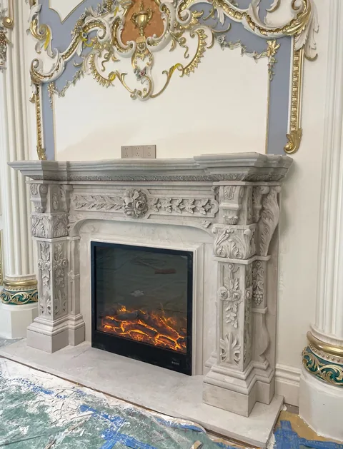 White Volakas marble fireplace surround, with fine veining, in a workshop