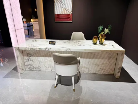 white stone desk, with fine veining and a reflective finish, in a showroom