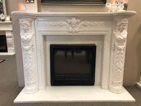 White Volakas marble fireplace surround, with fine veining, in a showroom