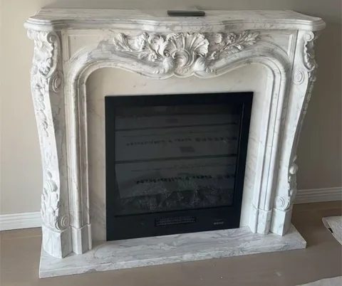 White Volakas marble fireplace surround, with fine veining, in a furnished room