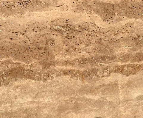 cream-beige stone slab, with linear travertine grain, in a close surface view