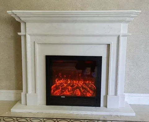 White Volakas marble fireplace surround, with stepped tiers and fine veining, in a furnished room