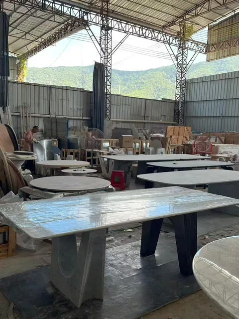 gray stone dining table, with twin supporting bases and a plain surface, in a workshop