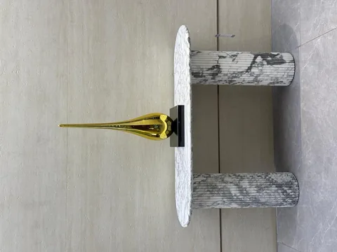 white stone console table, with twin supporting bases and bold veining, in a showroom