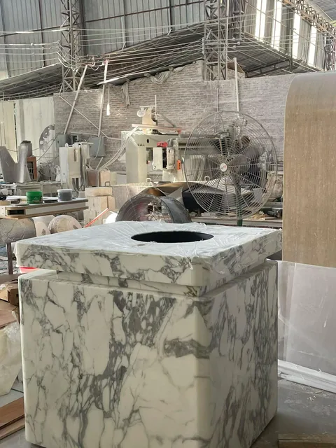 cream-beige stone vanity, with an integrated basin and bold veining, in a workshop