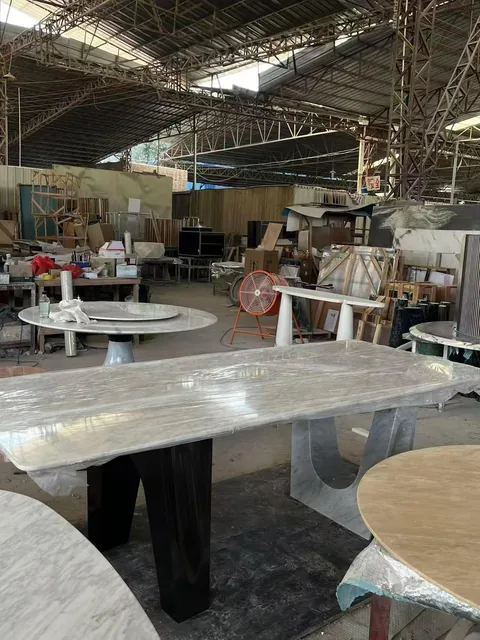 gray stone dining table, with twin supporting bases and fine veining, in a workshop