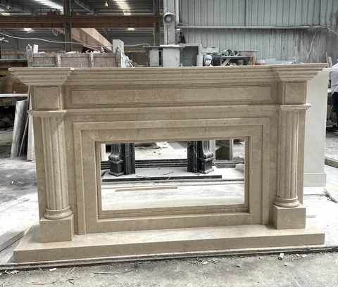White Volakas marble fireplace surround, with stepped tiers and cloudy mottling, in a workshop