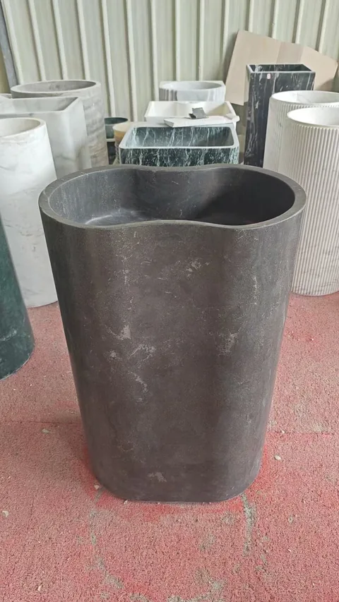 gray stone landscape feature, with a stone planter and a plain surface, in a workshop