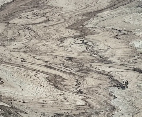cream-beige stone slab, with bold veining, in a close surface view