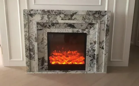White Volakas marble fireplace surround, with stepped tiers and bold veining, in a furnished room