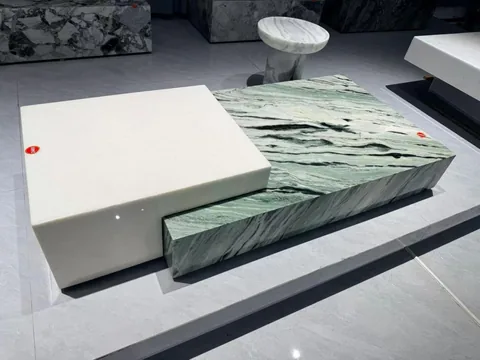 green stone coffee table, with bold veining and a reflective finish, in a showroom