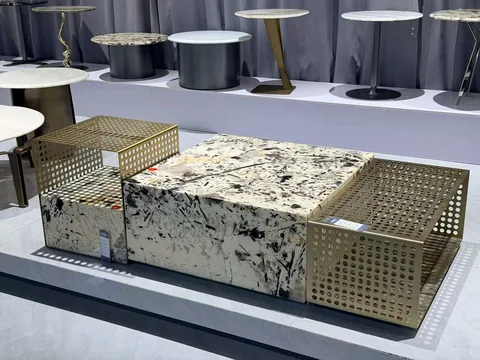 cream-beige stone coffee table, with angular breccia fragments and a reflective finish, in a showroom