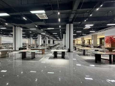 gray stone dining table, with fine veining and a reflective finish, in a showroom