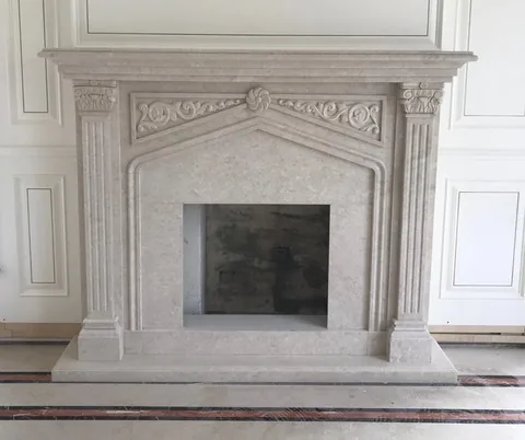 White Volakas marble fireplace surround, with cloudy mottling, against a pale background