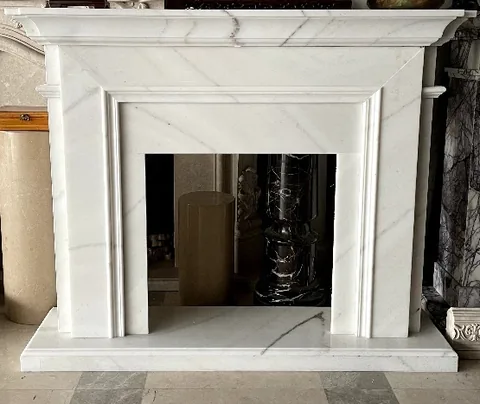 travertine fireplace surround, with stepped tiers and fine veining, in a showroom
