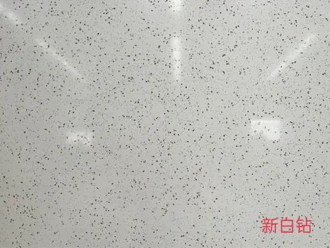 white engineered stone slab, with a single full slab and a speckled texture, in a close surface view