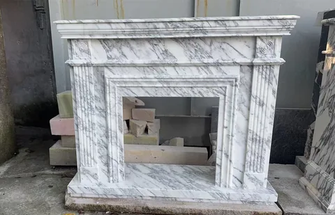 White Volakas marble fireplace surround, with fine veining, shown from a frontal view with strong pattern contrast