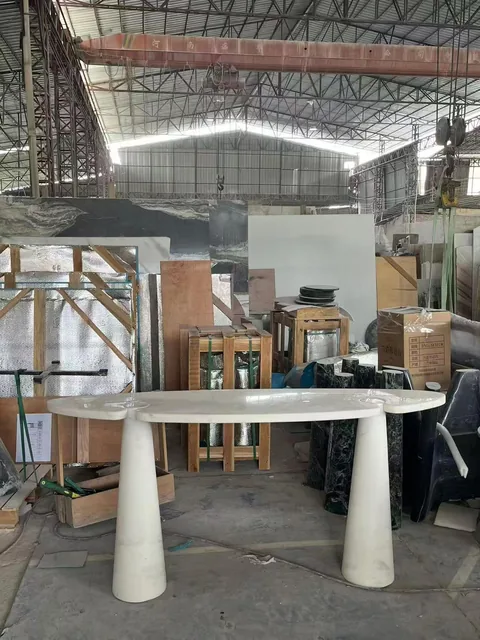 white stone dining table, with twin supporting bases and a plain surface, in a workshop