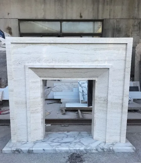 White Volakas marble fireplace surround, with stepped tiers and linear travertine grain, in a workshop