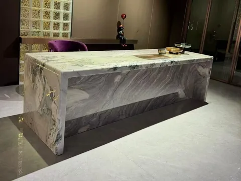 gray stone desk, with bold veining and a reflective finish, in a showroom