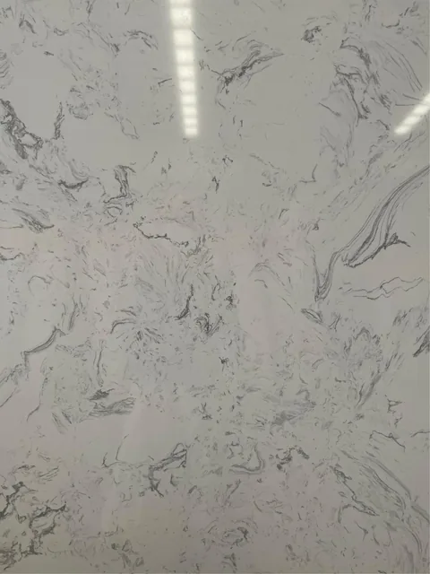 white engineered stone slab, with a single full slab and fine veining, in a close surface view