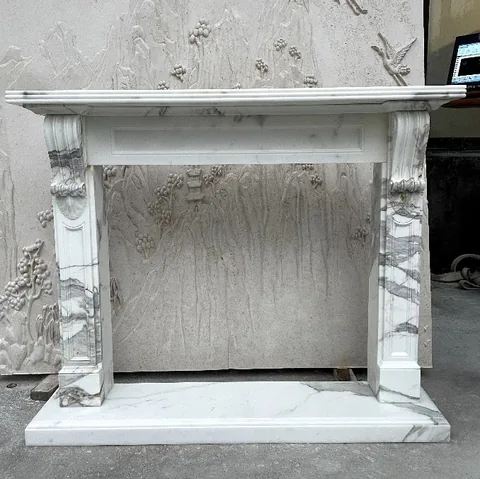 White Volakas marble fireplace surround, with bold veining, in a workshop